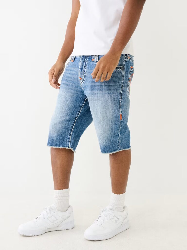 The Ricky Frayed Denim Short is a closet must have. This jean short features a zip fly, whiskering, five pocket construction, and white and orange Super T stitching. Finished with a frayed hem, vintage hardware, and horseshoe detailing on the back.